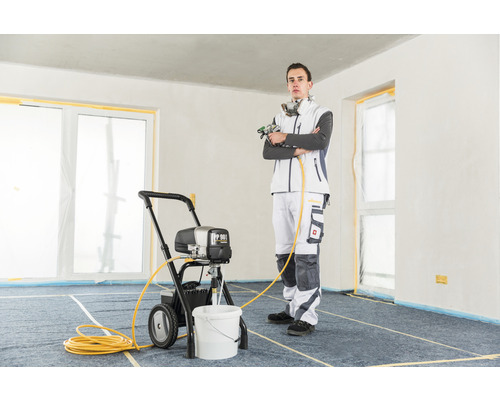 Man med färgspruta i ett rum.