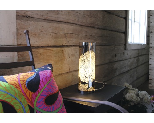 Dekorativ bordslampa med trämotiv på ett litet bord