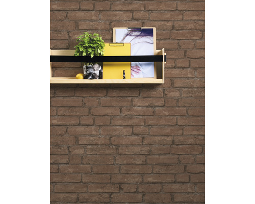 Trähylla på en tegelvägg med växt och kontorsmaterial