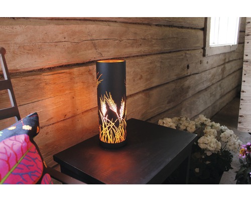 Dekorativ bordslampa med veteaxmönster på ett sidobord