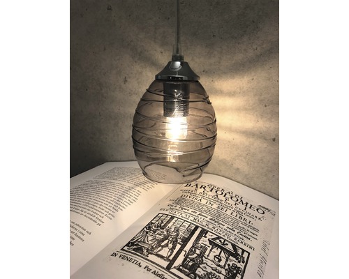 Hänglampa i glas ovanför en öppen bok