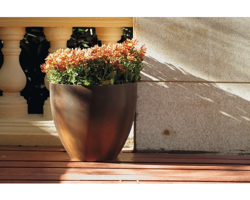 Blomkruka med blommande växter på en terrass