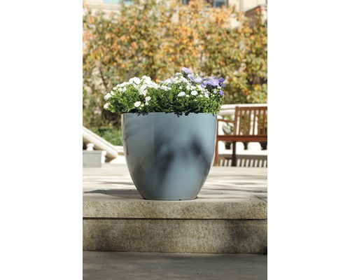 Blomkruka av plast med blommor på en stentrappa