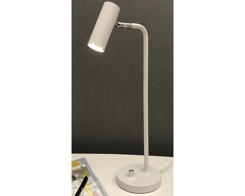 Vit skrivbordslampa på ett bord