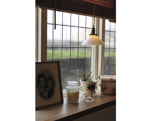 Fönsterbräda med dekorationer som ljus, växt och lampa