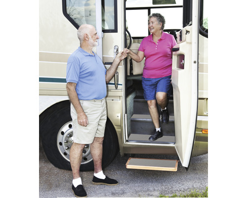 Ett par kliver ut ur en husbil med en utdragbar trappa.