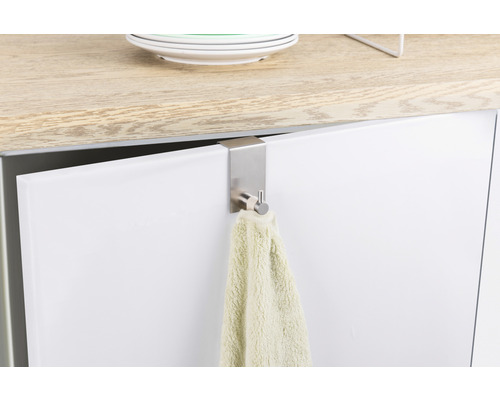 Handdukshängare i metall på en skåpdörr med handduk