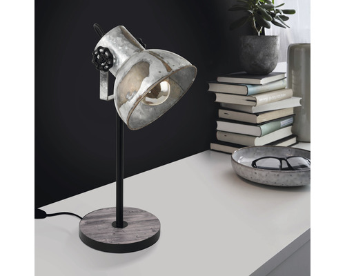 Bordslampa i metall med träfot på ett bord