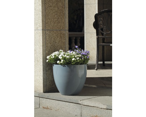 Blomkruka i plast med blommor på en terrass