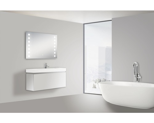 Badrum med tvättställ, belyst spegel och badkar