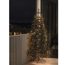 Julgran med ljusslinga på en balkong.