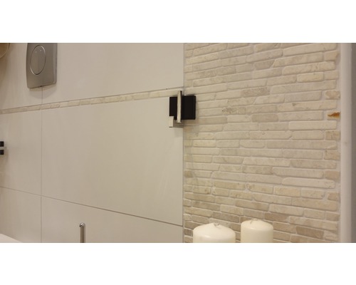 Detaljvy av ett badrum med kakelvägg och sanitetsartiklar