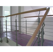 Interiörbild av ett trapphus med räcke i rostfritt stål och trä.