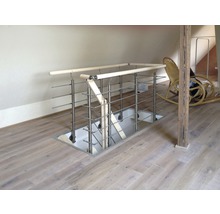 Vy över en trappnedgång med räcke i rostfritt stål i ett rum på vinden