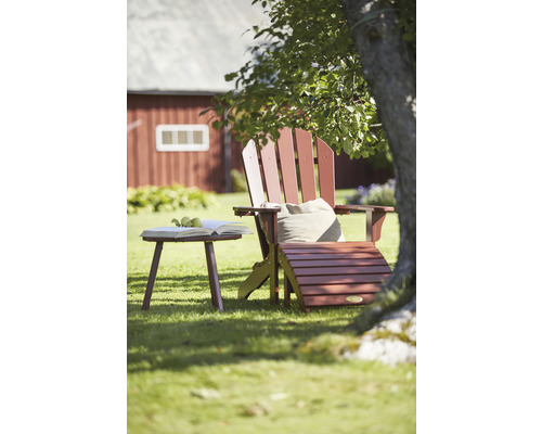 Trädgårdsscen med Adirondack-stol, sidobord, fotpall, bok och kudde
