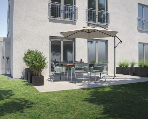 Trädgårdsscen med matbord, stolar, parasoll och blomlådor på en terrass