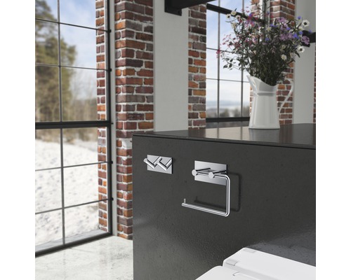 Modern badrumsscen med handdukskrokar och toalettpappershållare monterade på en vägg