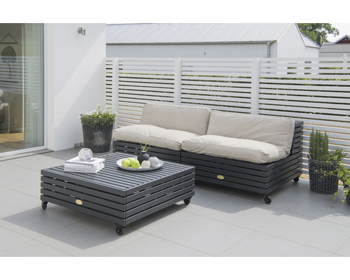 Terrass med loungemöbler av träribbor och ljusa dynor.