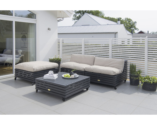 Trädgårdssittgrupp med soffa, pall och bord på en terrass