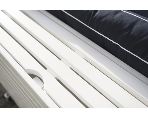 Detaljbild av en vit trädgårdsliggstol med dyna