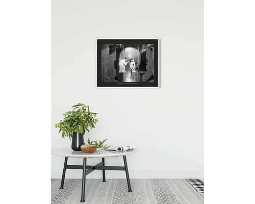 Inramat svartvitt fotografi med en scen från Star Wars på en vägg ovanför ett bord