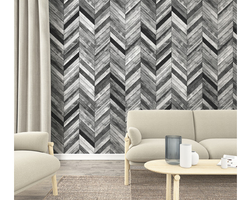 Vardagsrum med fiskbensmönstrad tapet i trälook, soffa och matta