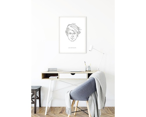 Scen med ett skrivbord med stol och ett inramat porträtt på väggen
