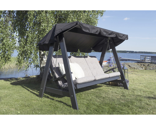 Trädgårdsgunga med tak och dynor på en gräsmatta