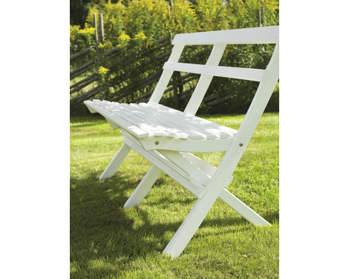 Trädgårdsscen med en vit hopfällbar stol på en gräsmatta