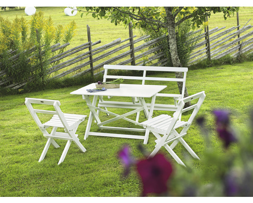 Trädgårdsscen med vitt trädgårdsbord, trädgårdsbänk och trädgårdsstolar på en gräsmatta