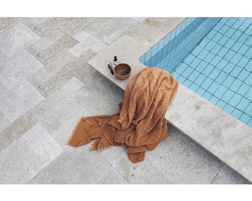 Överblick över en pool med handduk och hygienprodukter på stengolvet