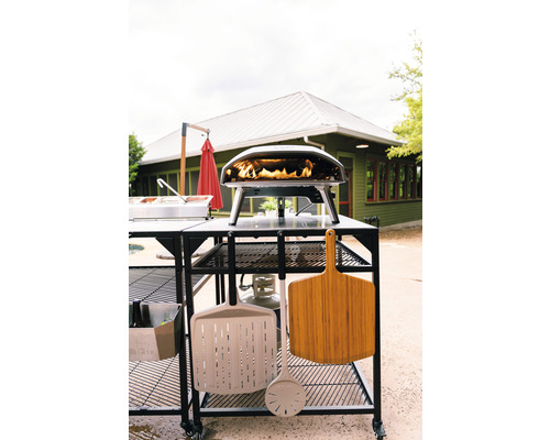 Pizza ugn med tillbehör på ett rullbord utomhus