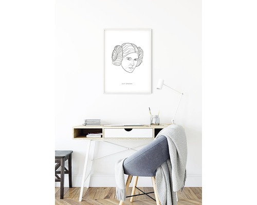 Scen med ett skrivbord, en stol och ett inramat konsttryck av Leia Organa på väggen.