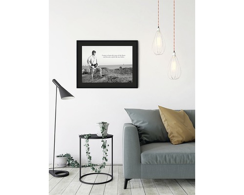 Vardagsrum med soffa, bordslampa, hänglampor och inramad Star Wars-affisch
