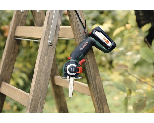 Batteridriven motorsåg på en trästege