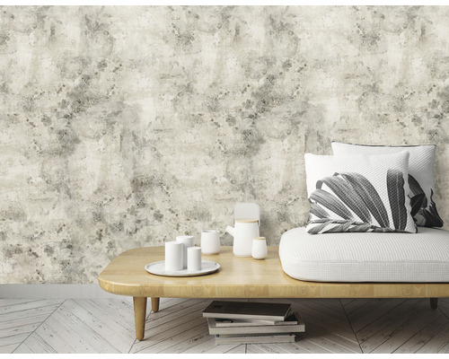 Vardagsrum med soffa, bord, porslin och beige tapet med stenlook