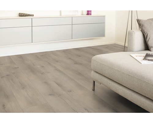 Ljust vardagsrum med laminatgolv i trälook och modern soffa