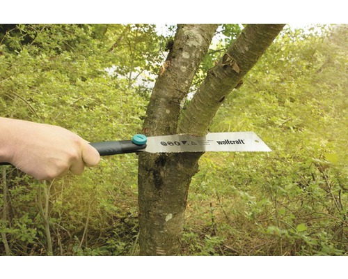 En handsåg från Wolfcraft sågar av en trädstam.