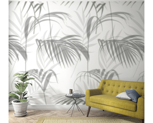 Vardagsrum med tapet med palmmotiv, soffa och krukväxt