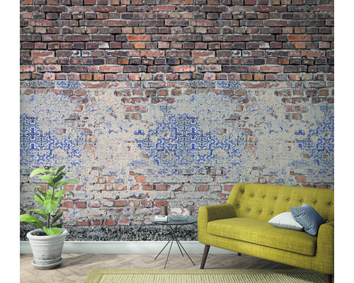 Rum med en väggtapet i tegeldesign, en soffa och en krukväxt.