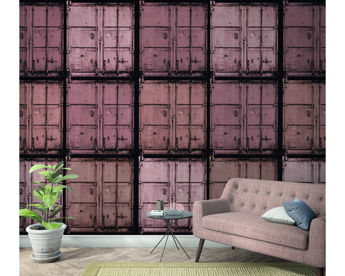 Vardagsrum med fototapet som visar staplade fraktcontainrar, soffa, sidobord och krukväxt.