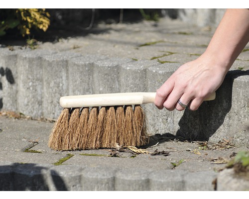 Hand sopar en stentrappa med en borste