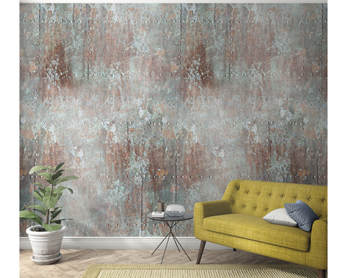 Vardagsrum med gul soffa, krukväxt och väggtapet i rostdesign