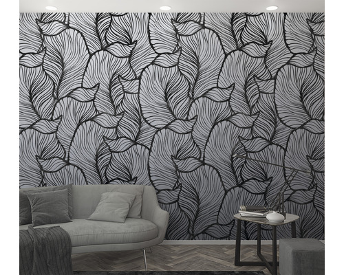 Vardagsrum med tapet med bladmönster, soffa och sidobord.