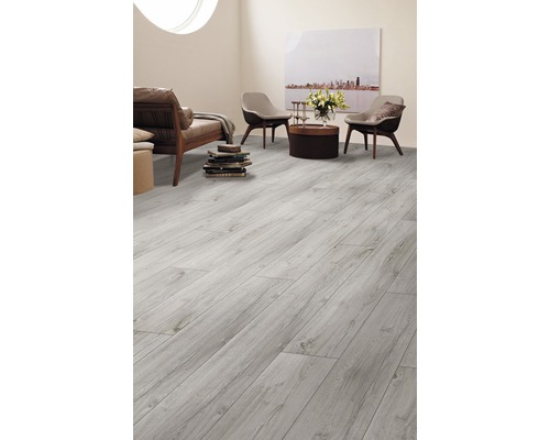 Ljust vardagsrum med laminatgolv i trälook, soffa, fåtöljer och dekoration