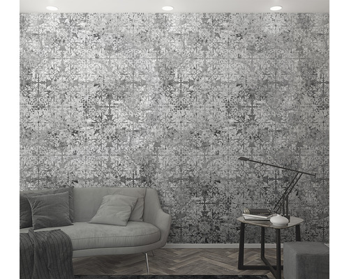 Vardagsrum med mönstrad tapet, soffa och sidobord med lampa.