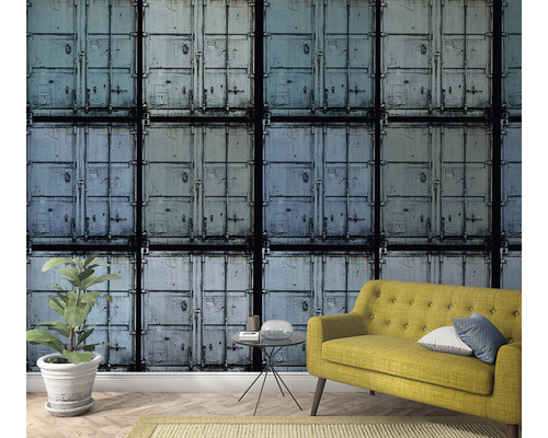 Rumsöversikt med tapet med containermotiv, gul soffa och krukväxt