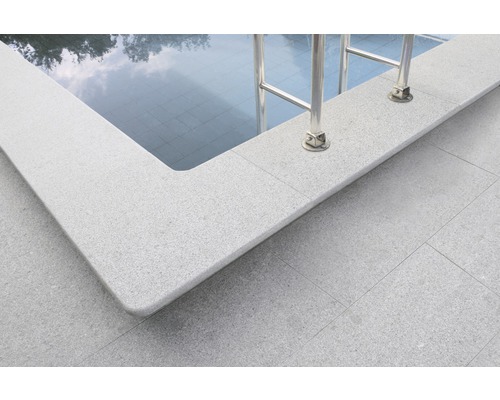 Detaljvy av en pool med poolkanter och stege.