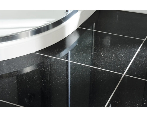 Detaljbild av kakel och duschkabin i badrummet.