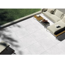 Terrass med ljusgrå plattor och trädgårdsmöbler